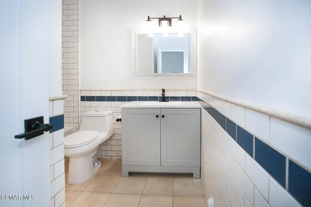 a bathroom with a sink a toilet and mirror