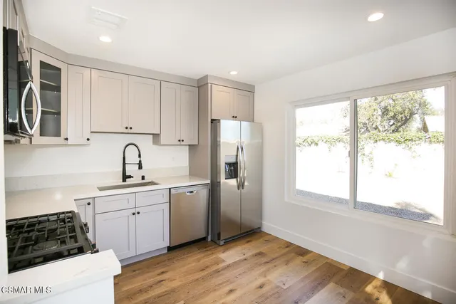 a kitchen with stainless steel appliances granite countertop a stove a sink and a refrigerator
