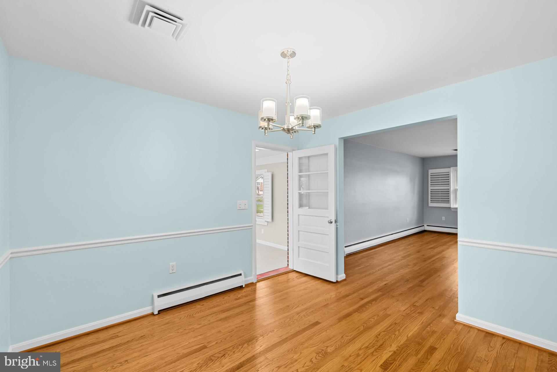 807 Winhall Way Silver Spring, MD 20904 - Photo 23 of 82 an empty room with wooden floor chandelier and windows