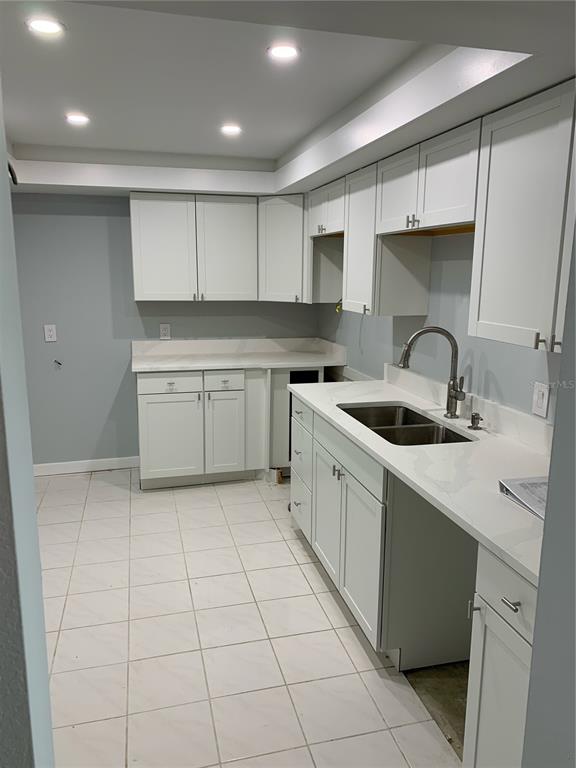 255 Dolphin Point, Unit 809 Clearwater, FL 33767 - Photo 4 of 16 a kitchen with a sink a stove and cabinets