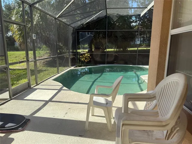 a view of a chairs and table in the patio with a backyard