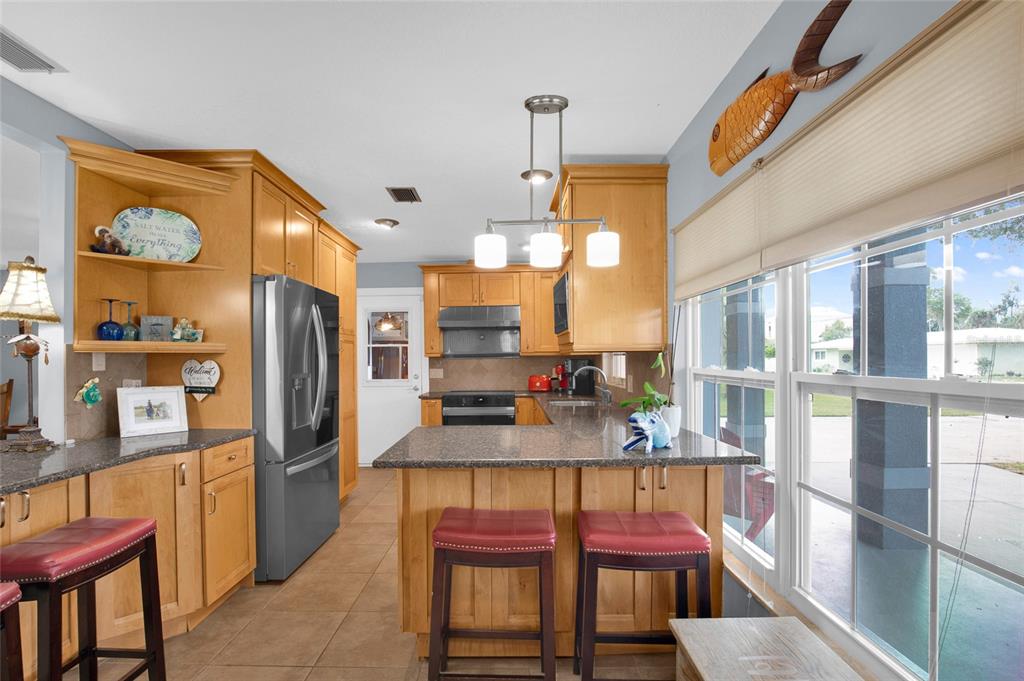 4121 South Roosevelt Point Homosassa, FL 34448 - Photo 14 of 47 a kitchen with stainless steel appliances granite countertop a refrigerator a stove and a dining table with wooden floor