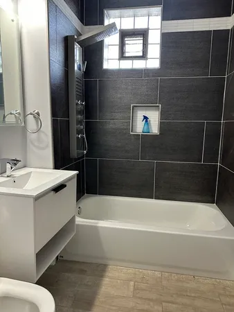 a bathroom with a bathtub a sink a vanity and window