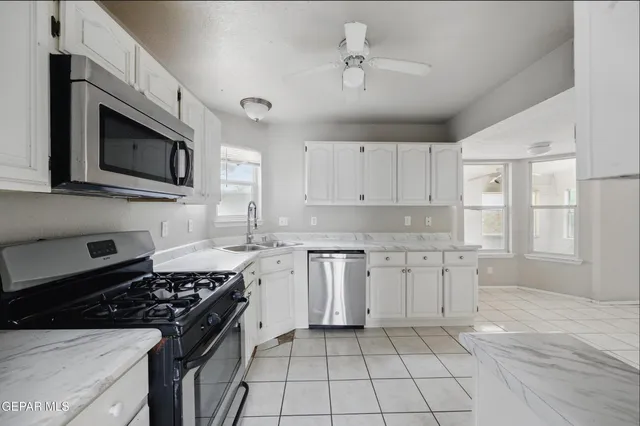 a kitchen with stainless steel appliances granite countertop a stove and a microwave