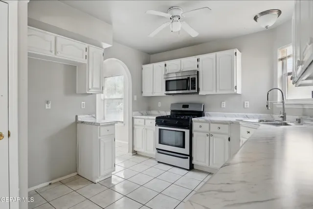 a kitchen with white cabinets and appliances