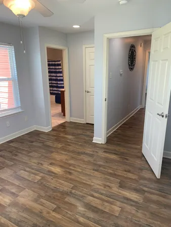 an empty room with wooden floor and window