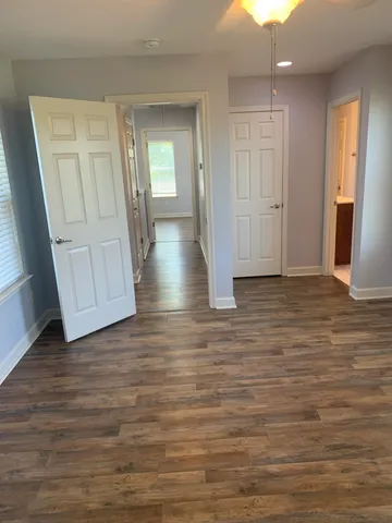 a view of empty room with wooden floor