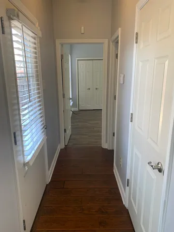 a view of a hallway with the wooden floor and entryway