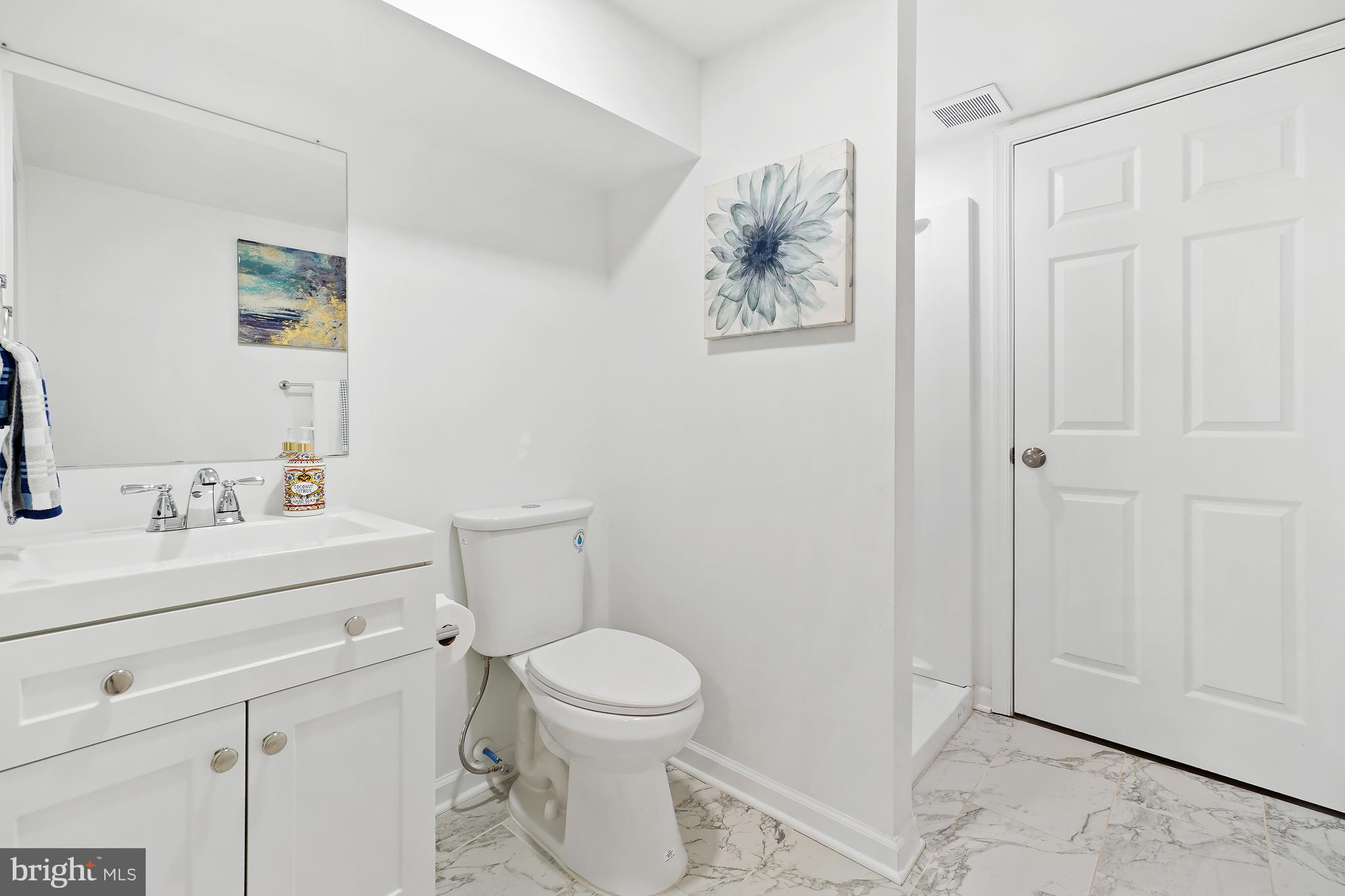 3731 Falls Road Baltimore, MD 21211 - Photo 11 of 30 a bathroom with a toilet sink vanity and mirror