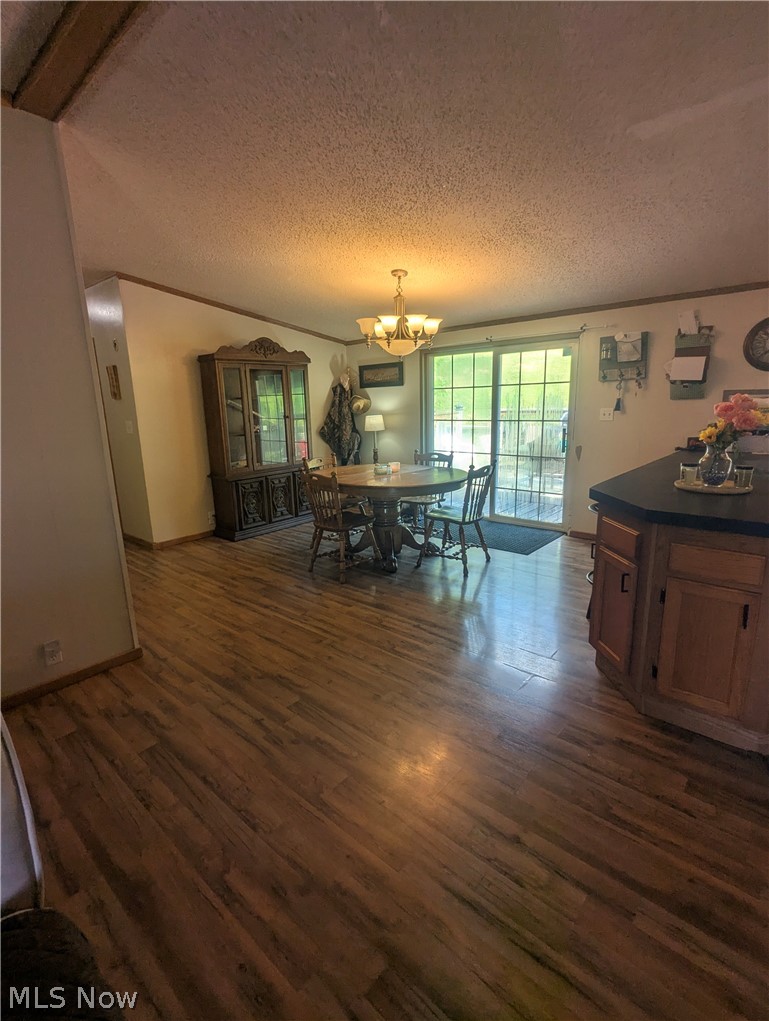 17960 Raven Road Salesville, OH 43778 - Photo 13 of 27 Dining area featuring wood-finish flooring, a multi-bulb chandelier, and sliding glass doors