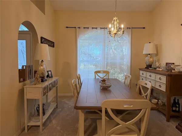 a view of a dining room with furniture and chandelier