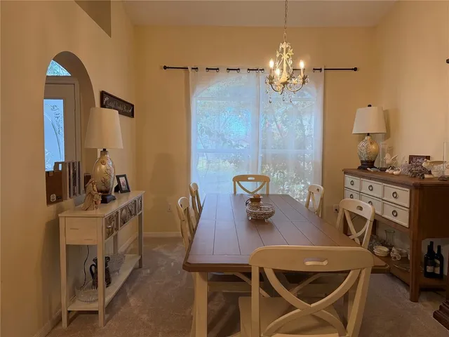 a view of a dining room with furniture and chandelier