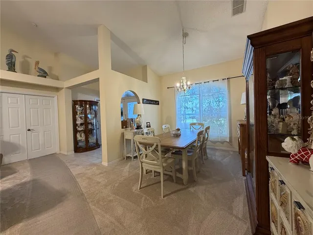 a view of a dining room and livingroom with furniture wooden floor a chandelier