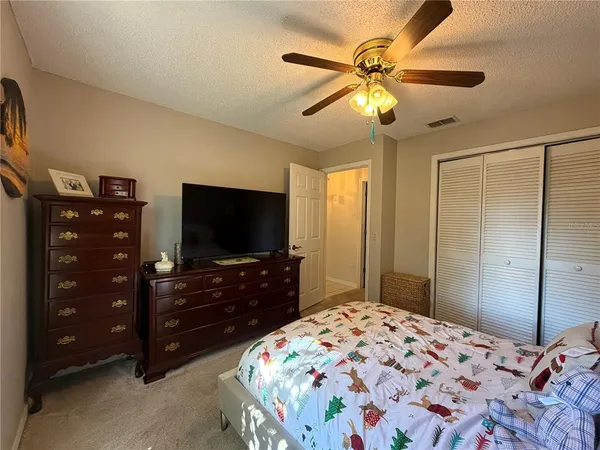 a bedroom with a bed and a flat tv screen on dresser