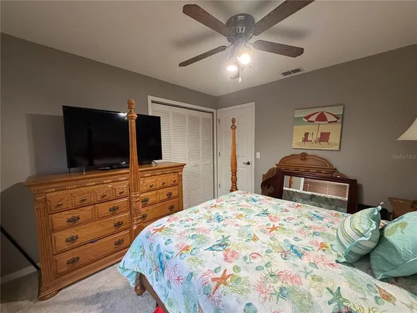 a bedroom with a large bed and a flat tv screen on dresser