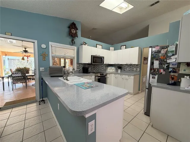 a kitchen with stainless steel appliances kitchen island granite countertop a sink and cabinets