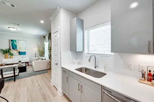 a kitchen with white cabinets and sink