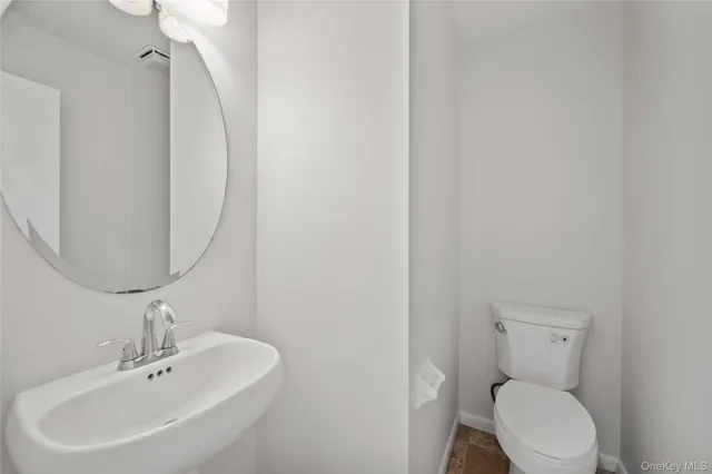 a white toilet sitting next to a bathroom sink
