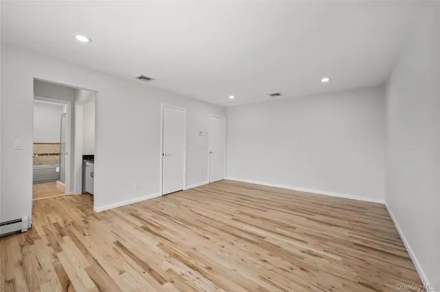 a view of empty room with wooden floor