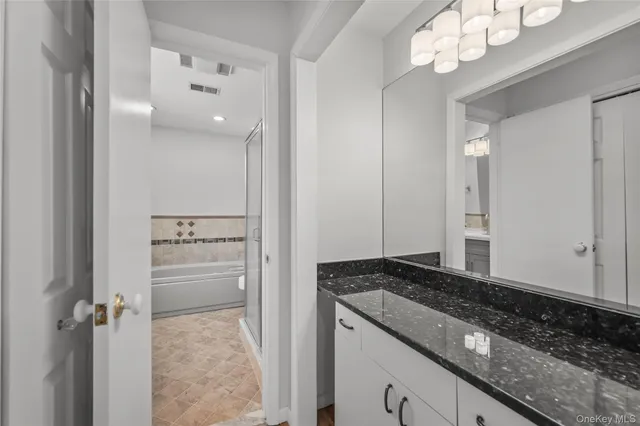 a bathroom with a granite countertop sink and a mirror