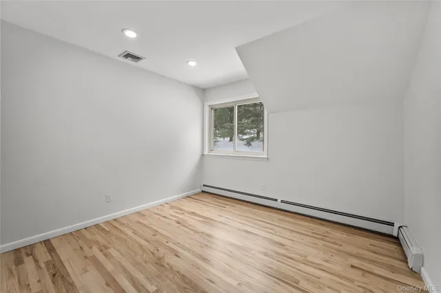 an empty room with a wooden floor and a window