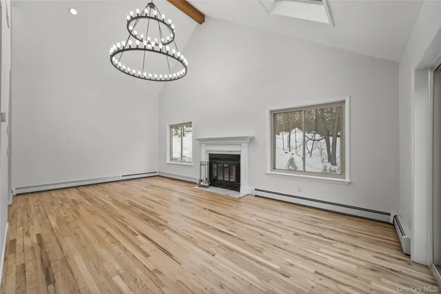 a view of empty room with wooden floor fireplace