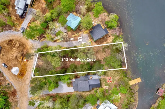 an aerial view of a house with a yard and lake view