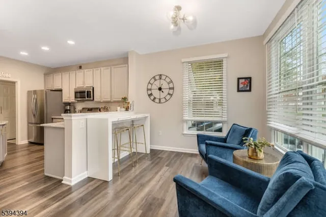 a living room with furniture a fireplace a flat screen tv and kitchen view