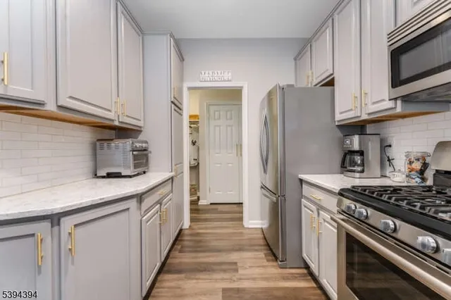 a kitchen with stainless steel appliances granite countertop a stove a refrigerator and a microwave