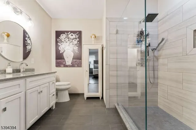 a bathroom with a double vanity sink a toilet and shower