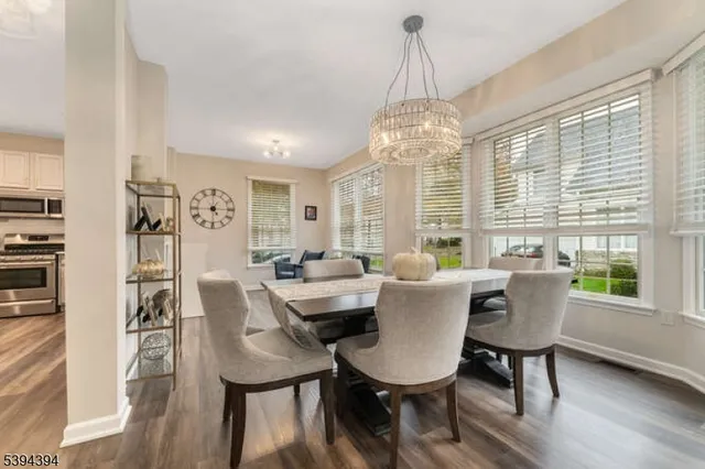 a dining room with furniture a chandelier and wooden floor