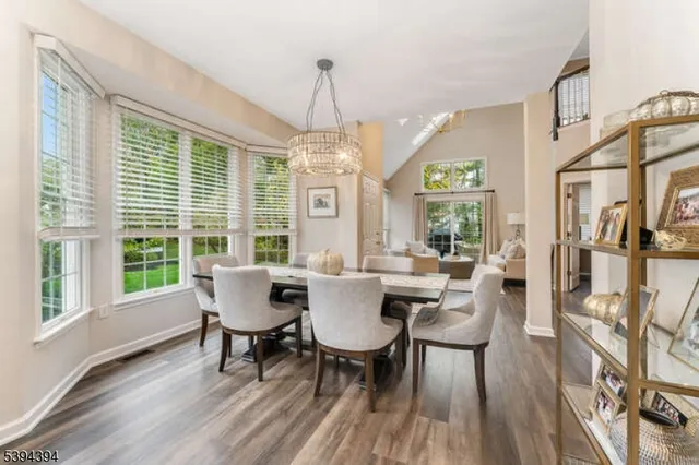 a dining room with furniture a chandelier and wooden floor
