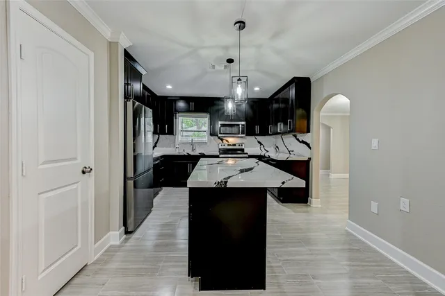 a kitchen with kitchen island a sink a stove and a refrigerator