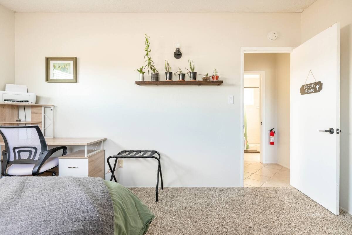 217 South Silver Ridge Street Ridgecrest, CA 93555 - Photo 15 of 20 a bedroom with a bed and a table with potted plant