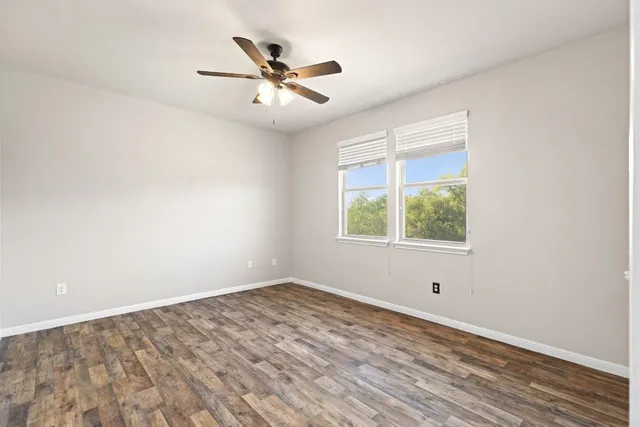 a bathroom with a granite countertop sink a toilet a mirror and shower