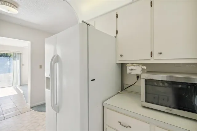 a kitchen with white cabinets and white appliances