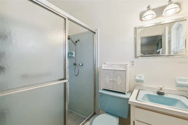 a bathroom with a toilet sink vanity and shower