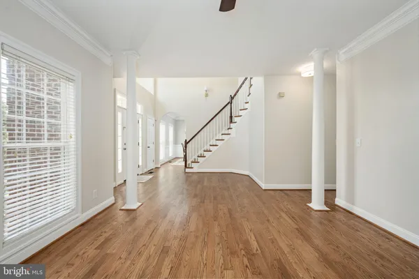 an empty room with wooden floor closet and windows