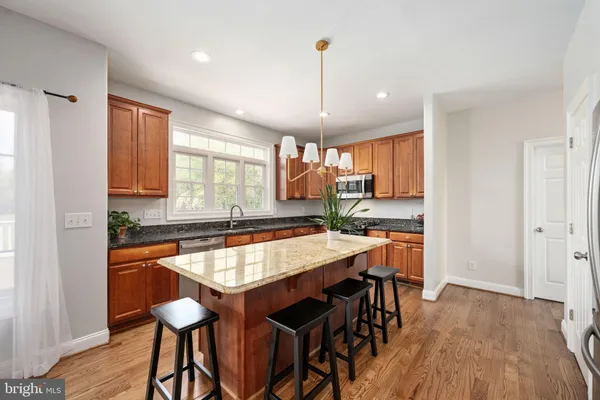a kitchen with stainless steel appliances granite countertop wooden cabinets a stove top oven a sink and dishwasher