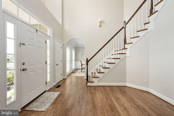 a large kitchen with stainless steel appliances granite countertop a refrigerator a sink dishwasher a stove a dining table and chairs with wooden floor