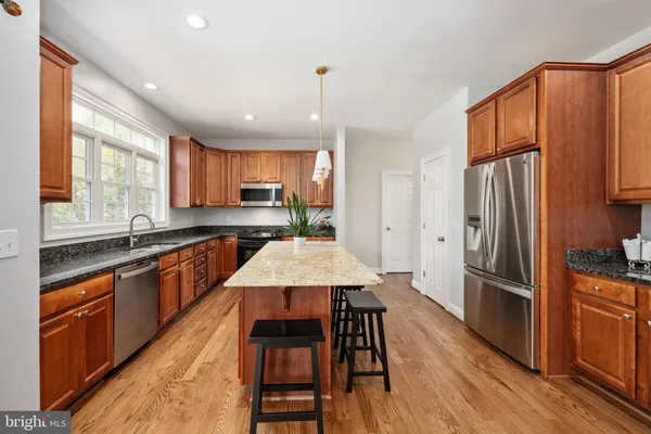 a large kitchen with stainless steel appliances granite countertop a granite counter tops and a wooden floors