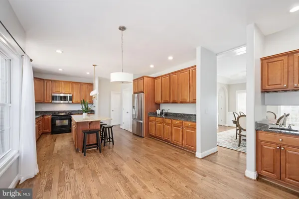 a view of an empty room with wooden floor fireplace and a window
