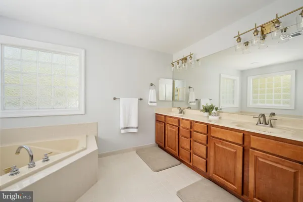 a en suite bathroom with a double vanity sink a mirror and a toilet