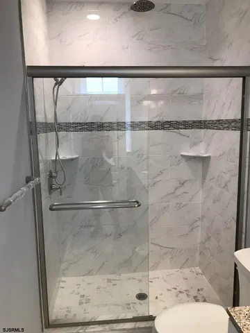 a bathroom with a granite countertop sink toilet and shower