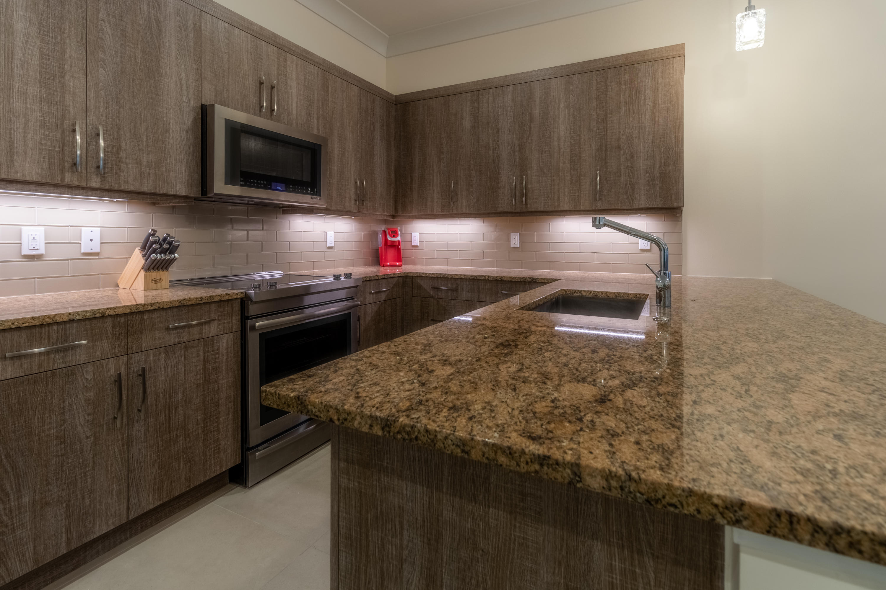 1085 Phillips Road Delray Beach, FL 33483 - Photo 5 of 32 a kitchen with stainless steel appliances granite countertop a sink stove and microwave