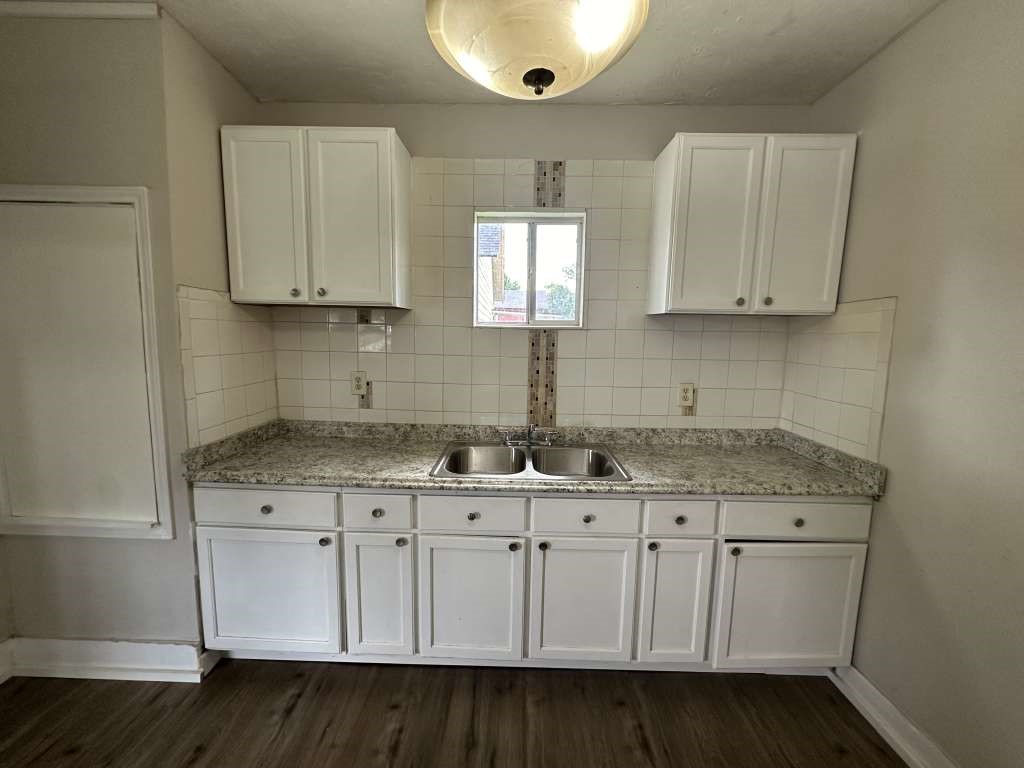 4520 Falls Street Houston, TX 77026 - Photo 7 of 11 a kitchen with granite countertop white cabinets and a sink