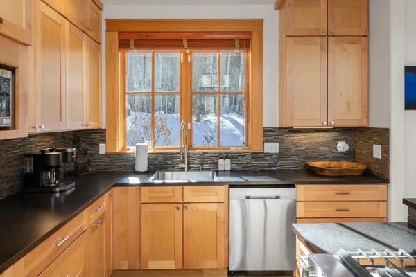 a kitchen with stainless steel appliances granite countertop a stove a sink and a microwave