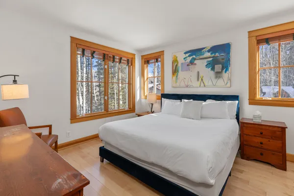 a bedroom with a bed and wooden floor