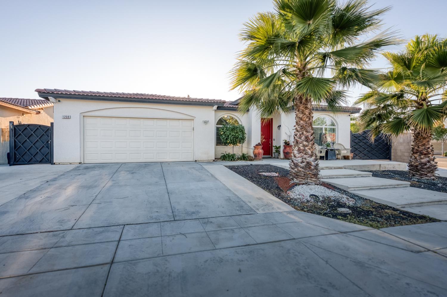 1208 Monterey Street Madera, CA 93637 - Photo 2 of 38 a view of a house with a yard and palm trees