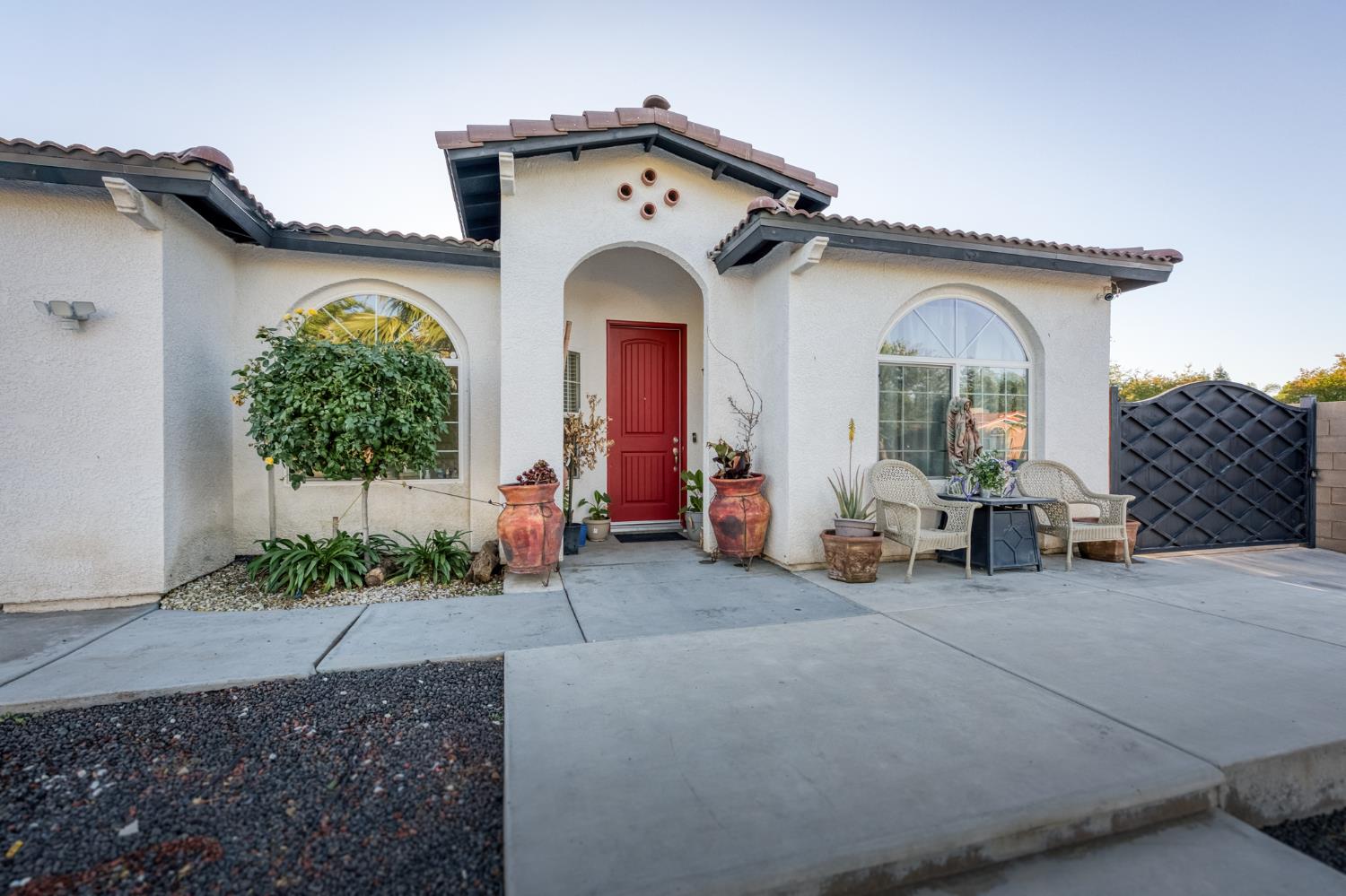 1208 Monterey Street Madera, CA 93637 - Photo 7 of 38 a view of a house with large windows and potted plants